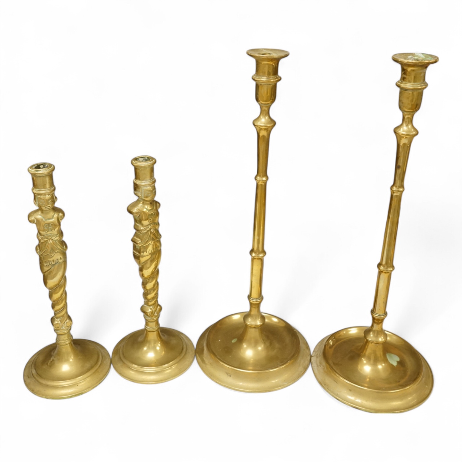 Two pairs of brass candlesticks to include a pair of figural examples, largest 47cm high